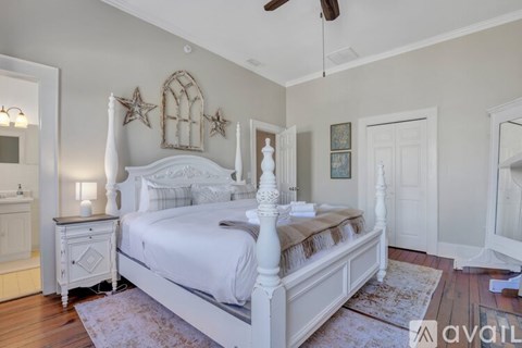 A bedroom with a large bed and a ceiling fan.