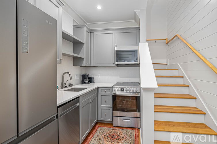 A kitchen with a refrigerator, oven, and microwave.