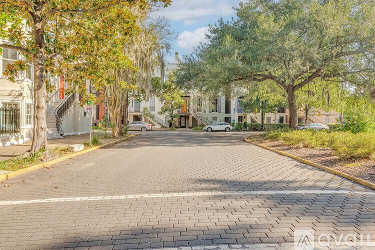A tree-lined street with a car parked on the side.