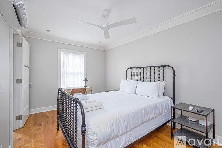 A bedroom with a large bed and a ceiling fan.