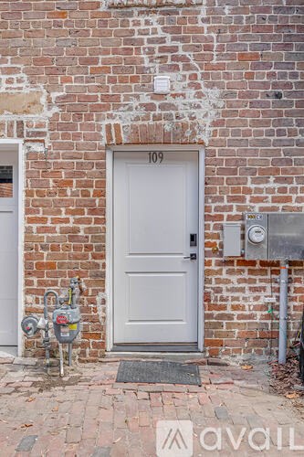 A white door with a mailbox on the brick wall.