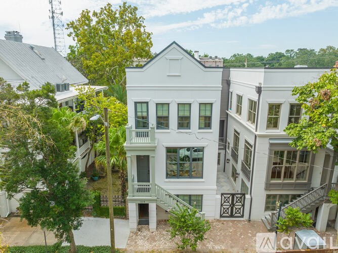 A white two-story building with a balcony on the second floor.