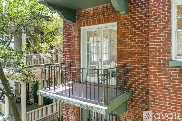 A red brick house with a balcony.