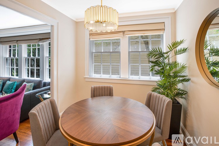 A dining room with a wooden table and chairs.