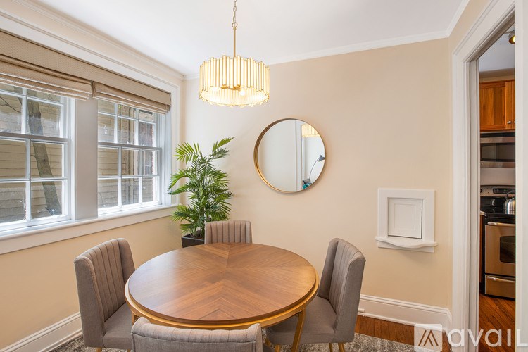 A dining room with a round table and chairs.