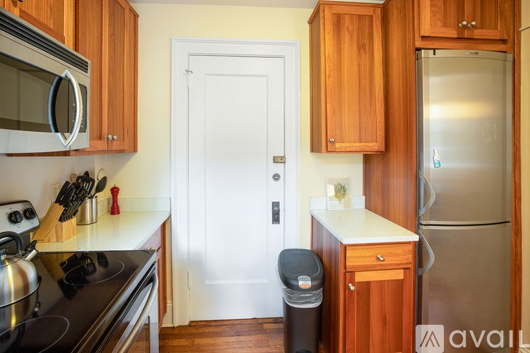 A kitchen with wooden cabinets and a black stove top oven.
