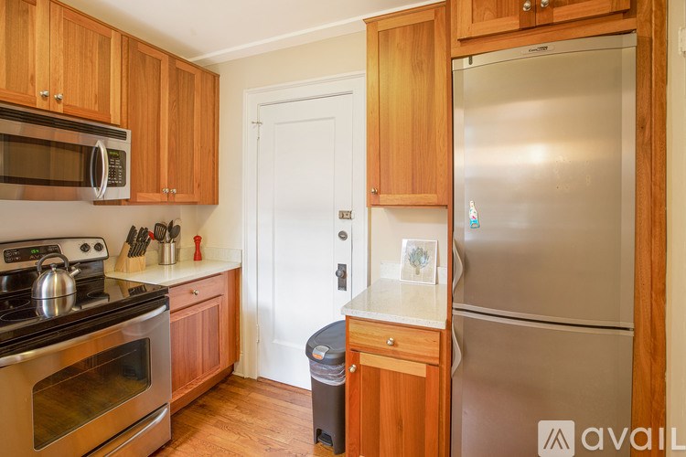 A kitchen with wooden cabinets and a stainless steel refrigerator.