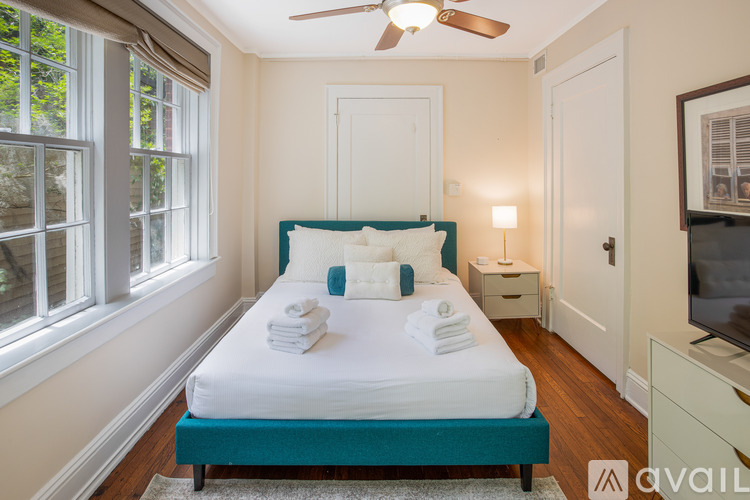 A bedroom with a bed, a window, a ceiling fan, and a dresser.