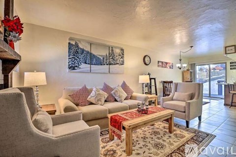 A living room with a large painting of a snowy landscape on the wall.