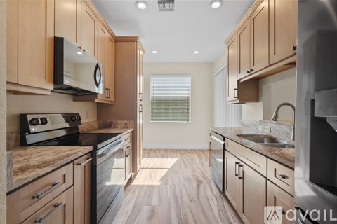 A kitchen with wooden cabinets and a granite countertop.