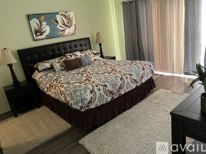 A bedroom with a large bed and a painting above it.