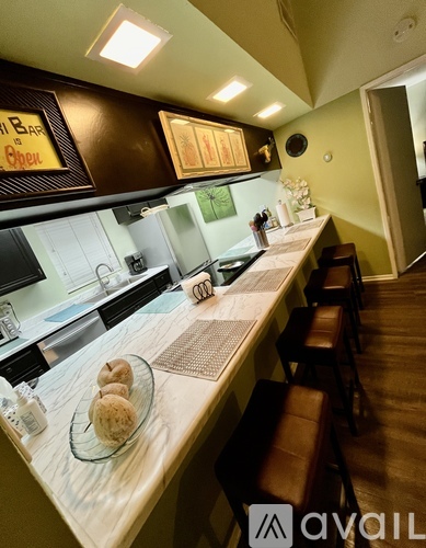 A kitchen with a counter and stools.
