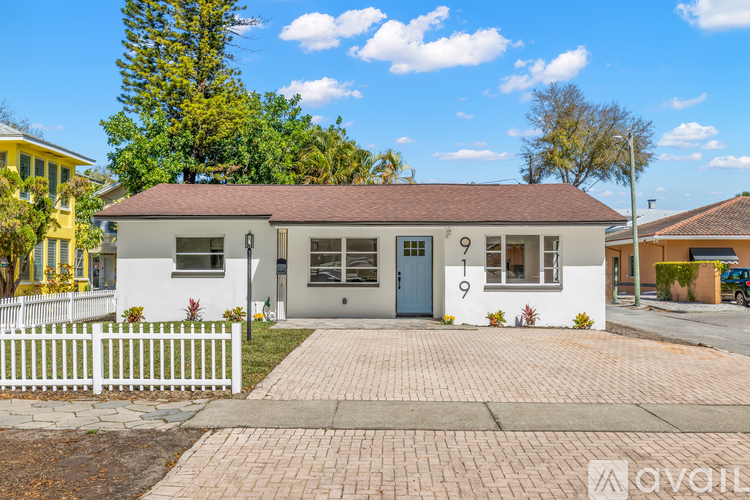 A small white house with a brown roof and a number 9 on the front door.