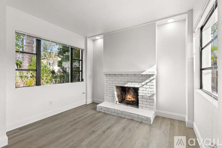 A modern living room with a fireplace and large windows.