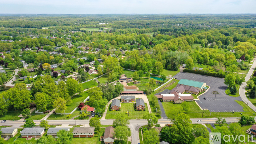A bird's eye view of a residential area with a swimming pool and a road.