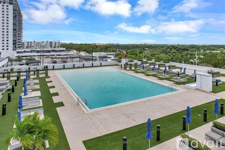 A large outdoor swimming pool surrounded by lounge chairs and umbrellas.