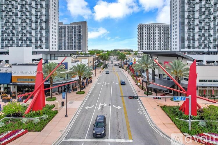 A street view with a car driving on the road and buildings on both sides.