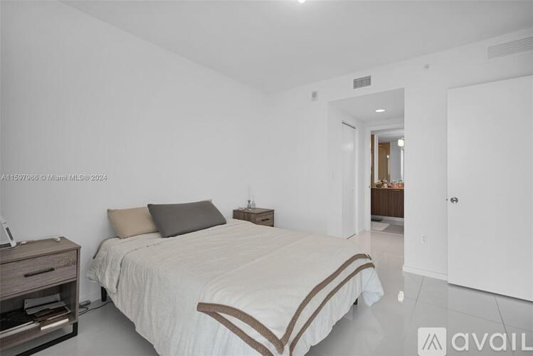 A bedroom with a bed, nightstand, and a wall-mounted shelf.