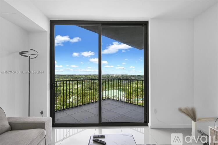 A modern living room with a view of the sky through a large window.