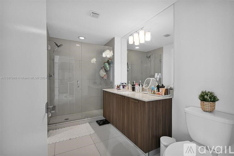 A modern bathroom with a large mirror and a white bathtub.