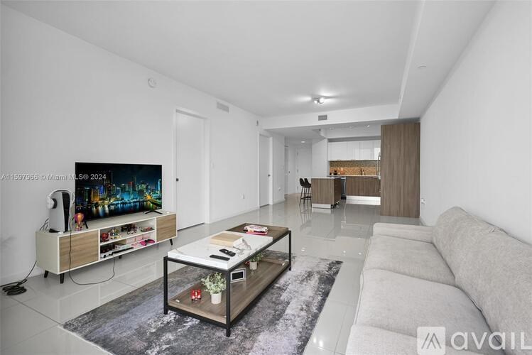 A modern living room with a flat screen TV and a coffee table.