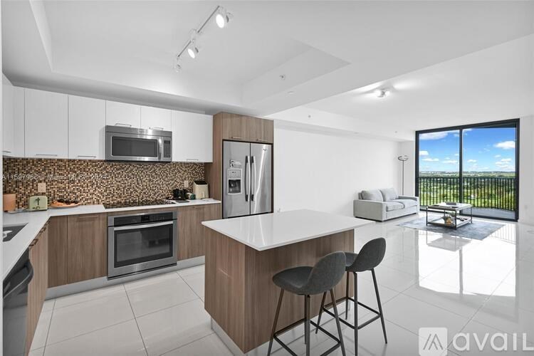A modern kitchen with a large island and a view of the outdoors.