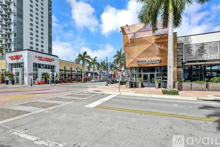 A street view with a building that has a geometric design on the front.
