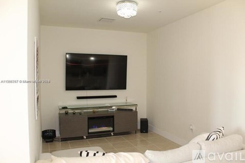 A living room with a television and a fireplace.