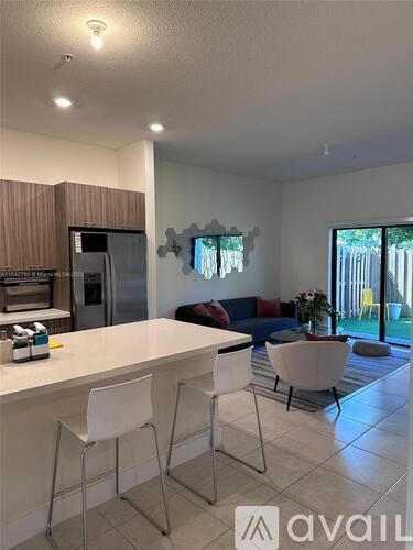 A kitchen with white chairs and a white counter.