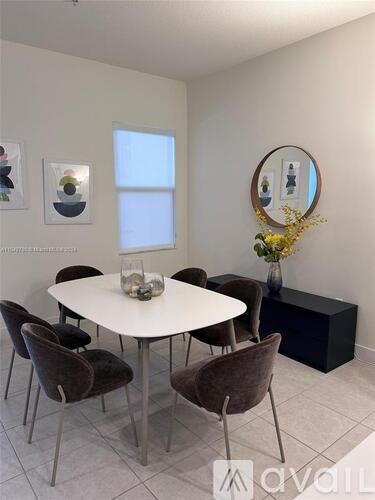 A white dining table surrounded by brown chairs in a room.