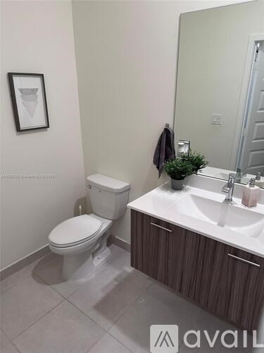 A bathroom with a toilet, sink, and a mirror.