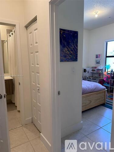 A room with a bed and a painting on the wall.