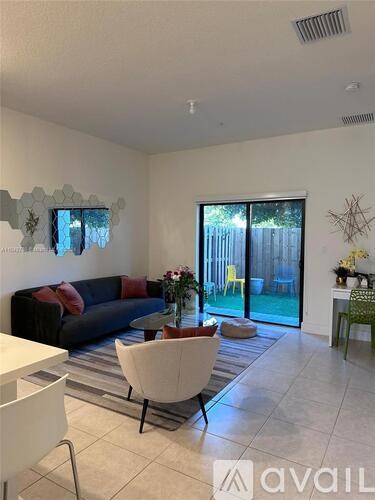 A living room with a couch, chairs, and a dining table.