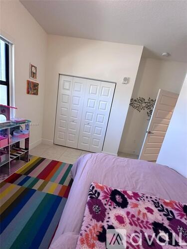 A bedroom with a bed, a dresser, and a window.