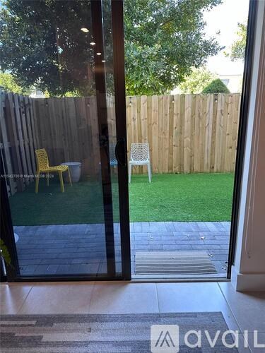 A patio with a table and chairs is visible through a glass door.