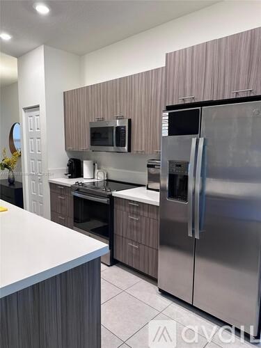 A modern kitchen with a stainless steel refrigerator and microwave.