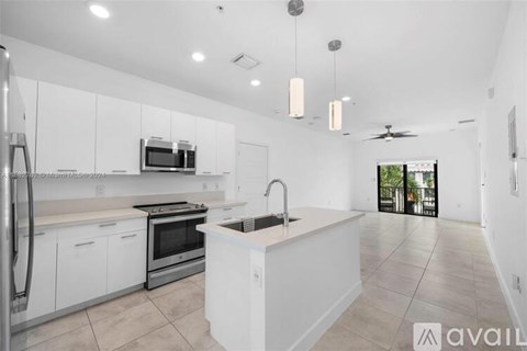 A modern kitchen with white cabinets and stainless steel appliances.