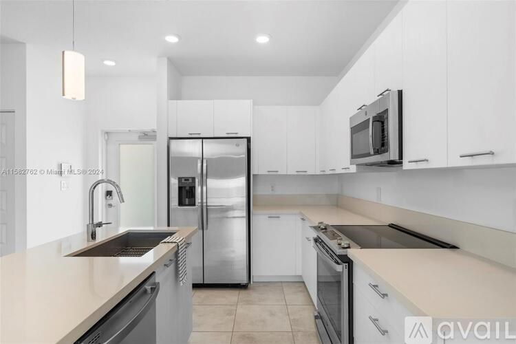 A kitchen with white cabinets and stainless steel appliances.