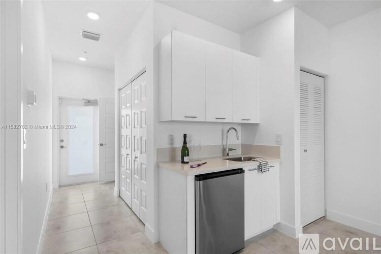 A kitchen with white cabinets and a black dishwasher.