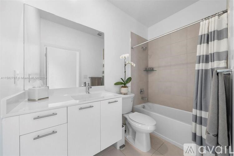 A white bathroom with a toilet, sink, and bathtub.