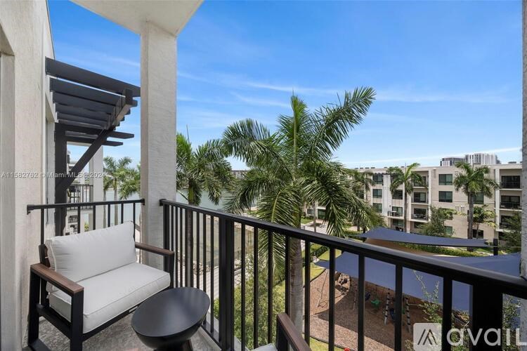 A balcony with a chair and table overlooking a courtyard.