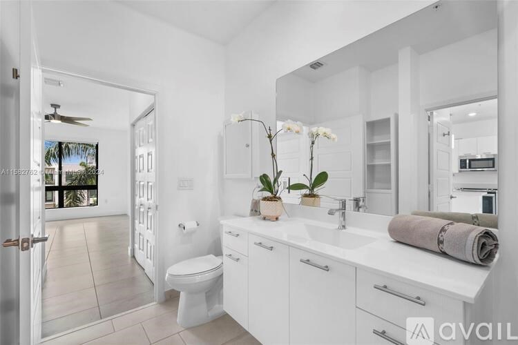 A white bathroom with a toilet, sink, and mirror.