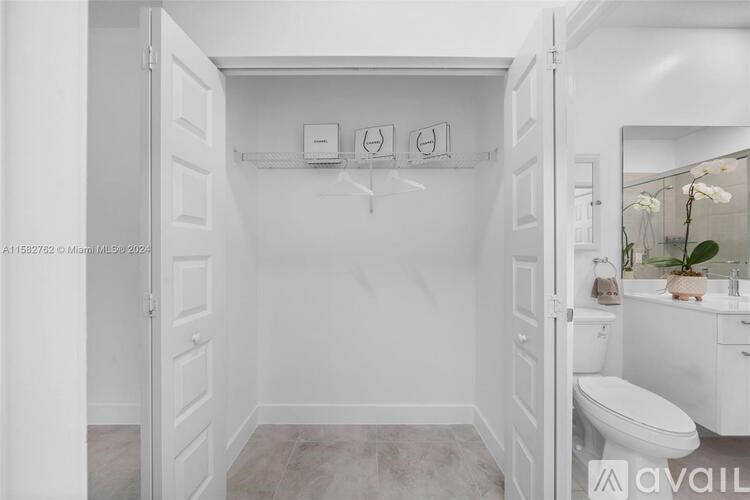 A white bathroom with a toilet and a mirror.