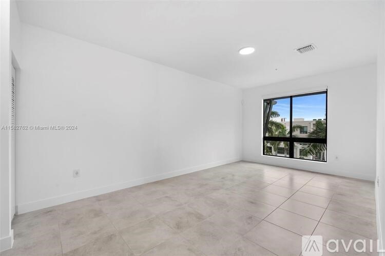 A large empty room with a window overlooking a cityscape.