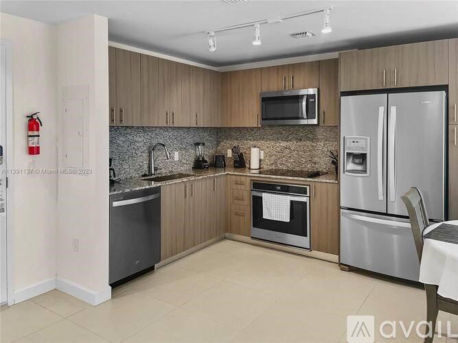 A kitchen with a stainless steel refrigerator, microwave, and oven.