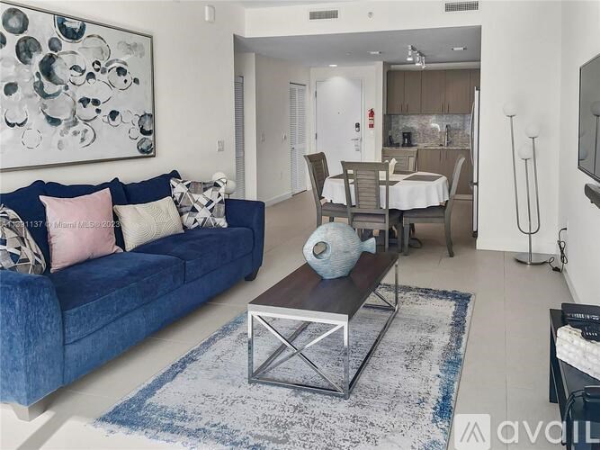 A blue couch with a white and pink pillow is in the living room.