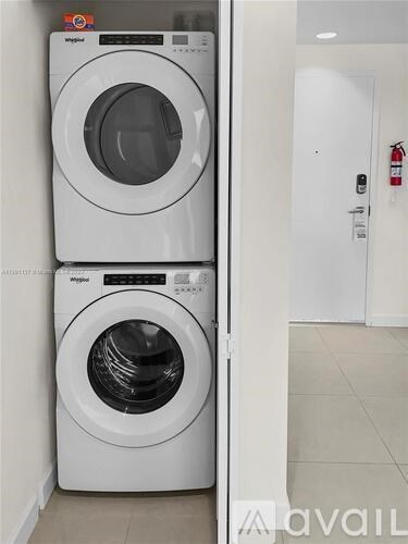 A white washing machine and dryer in a laundry room.
