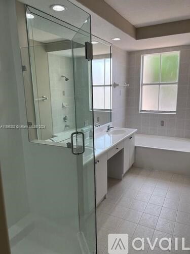 A bathroom with a glass shower door and a white sink.
