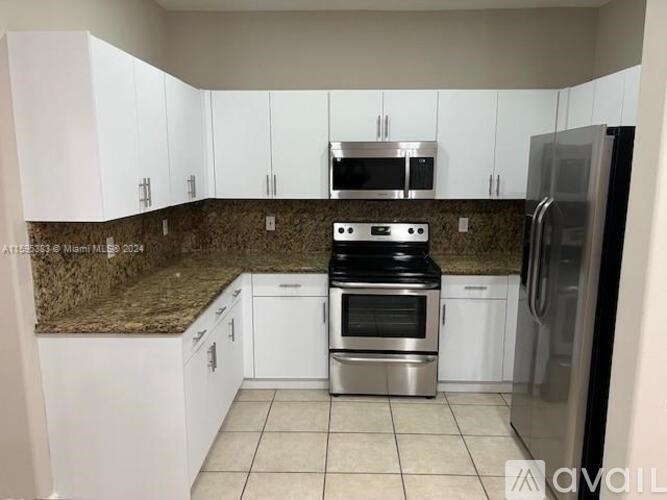 A kitchen with granite countertops and stainless steel appliances.
