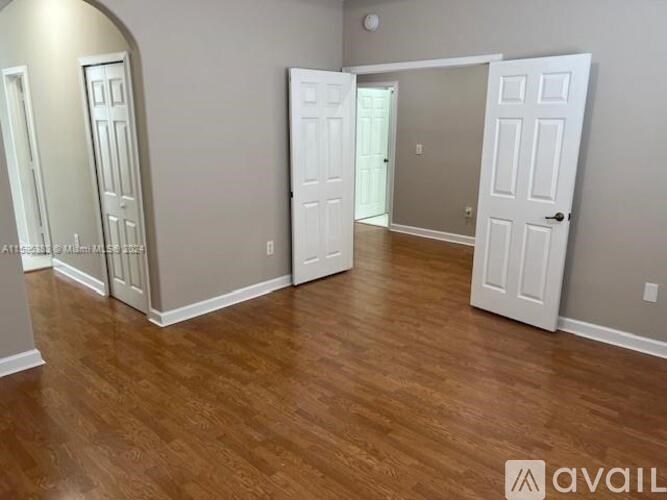 A room with wooden flooring and white doors.
